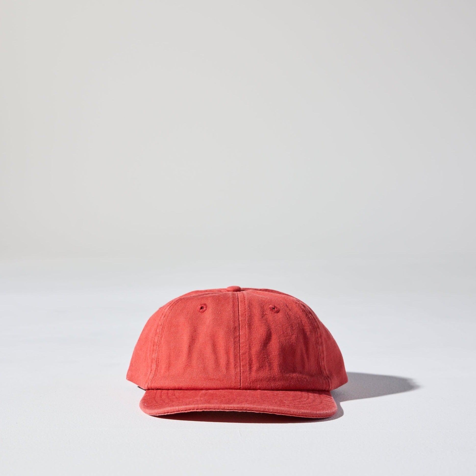 A red 6 panel snapback cap made of recycled cotton twill, displayed against a neutral background.