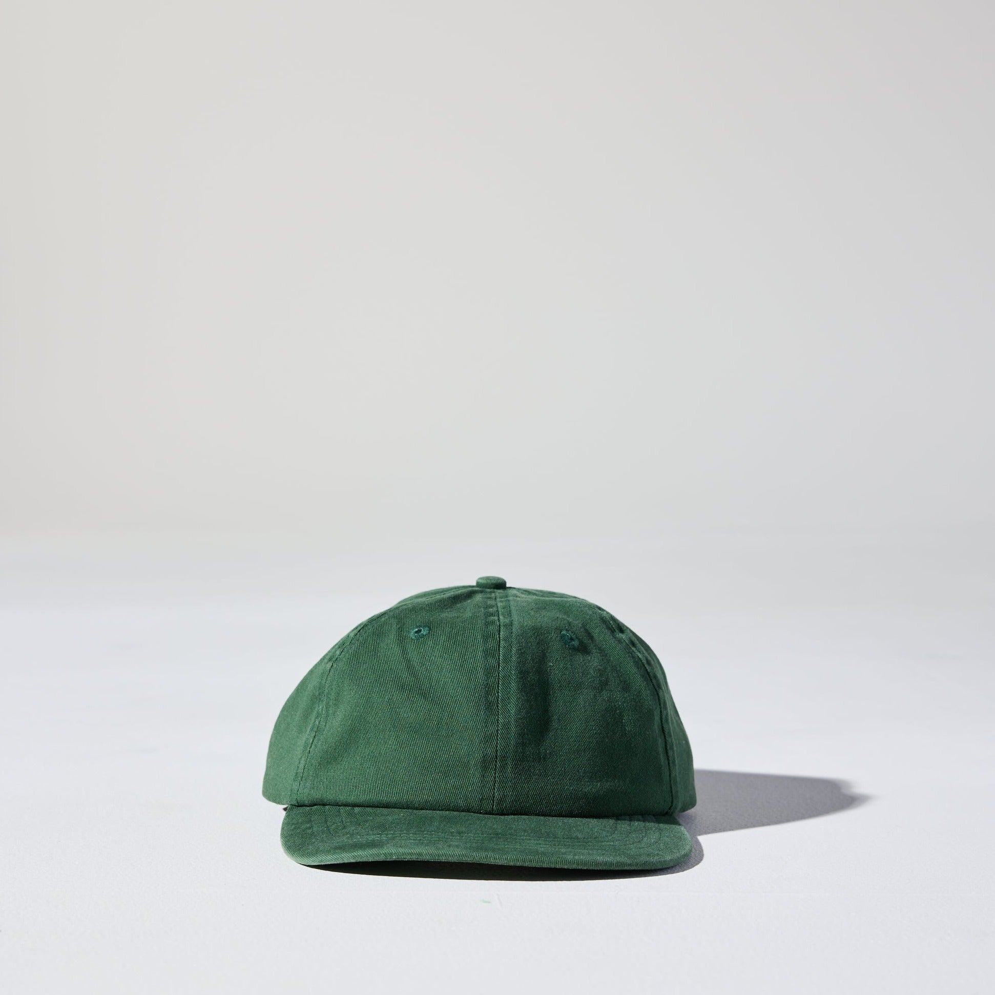 A faded forest green retro vibe Monday Buckle Cap by House of Peaks with an adjustable strap, placed against a white background.
