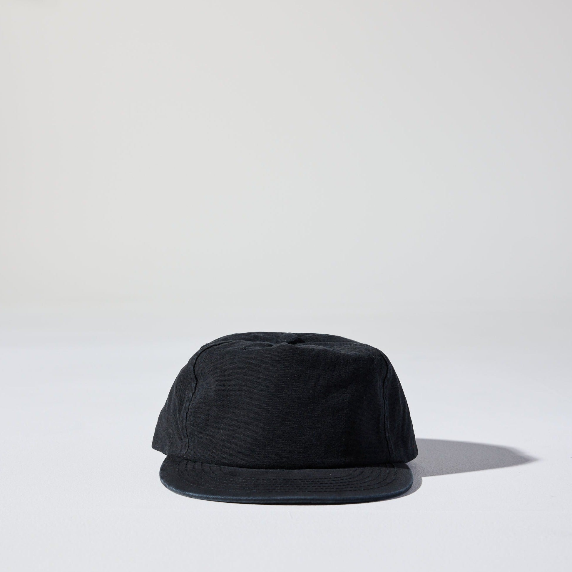 The Tomorrow Cap by House of Peaks is an ebony black 5 panel structured cap with a flat peak and an adjustable snap closure. Perfect for larger heads.