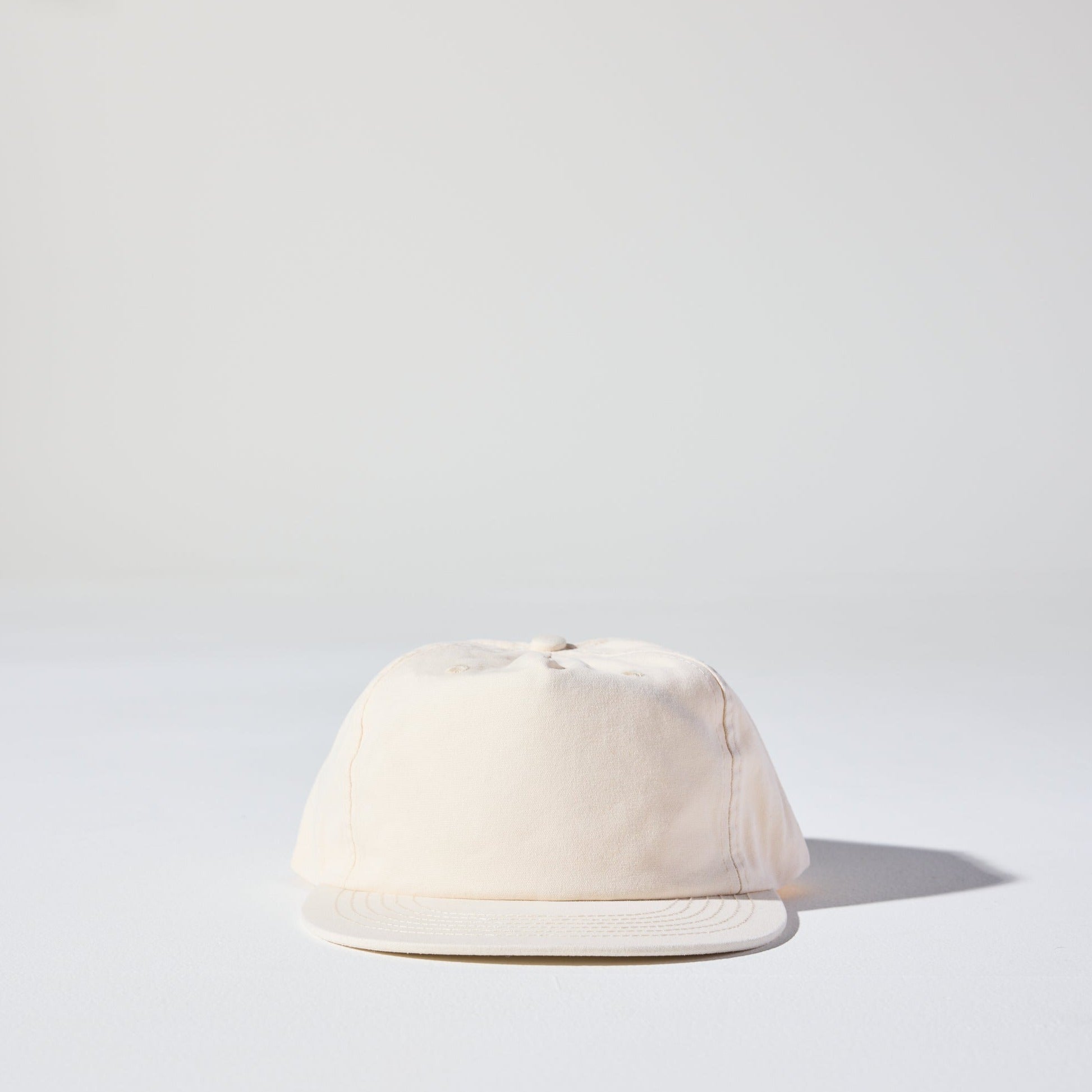 The Tomorrow Cap by House of Peaks is an ivory cream 5 panel structured cap with a flat peak and an adjustable snap closure. Perfect for larger heads.