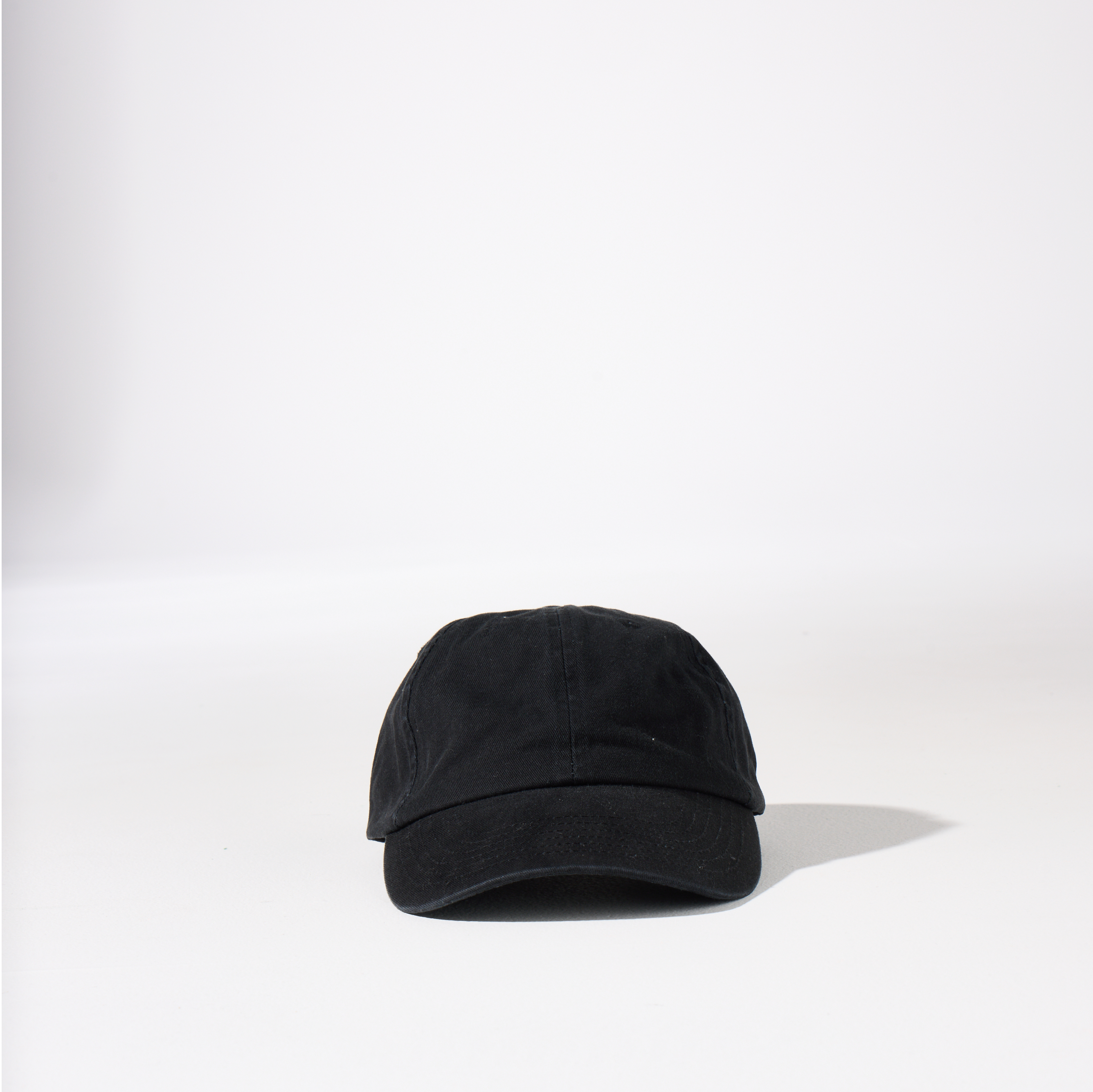 A washed black-coloured, 6-panel unstructured 'Dad' cap made of recycled cotton twill with an adjustable material buckle. Best Blank Hats by House of Peaks.