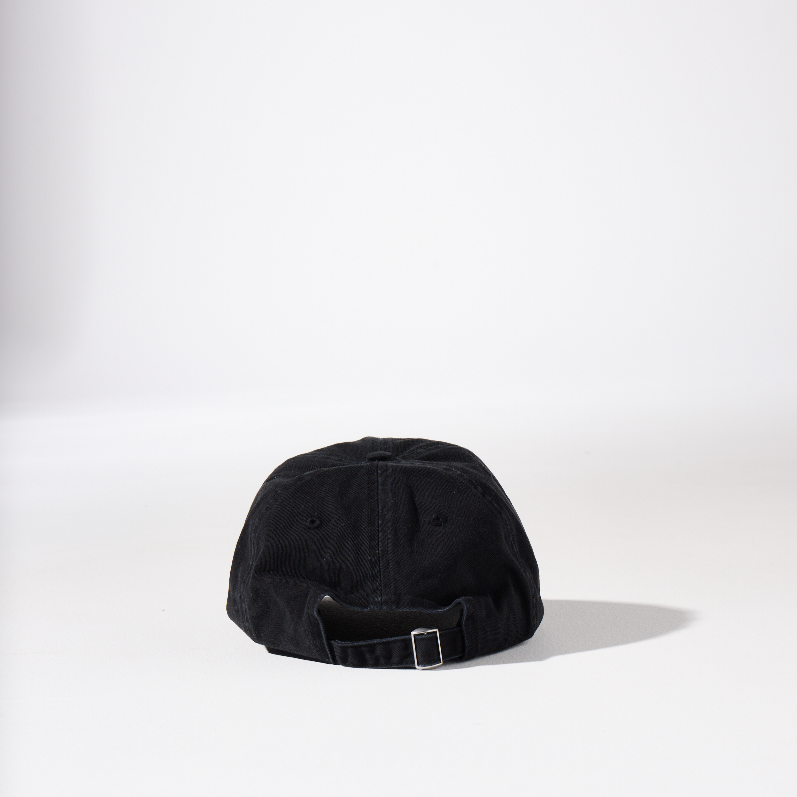 A washed black-coloured, 6-panel unstructured 'Dad' cap made of recycled cotton twill with an adjustable material buckle. Best Blank Hats by House of Peaks.