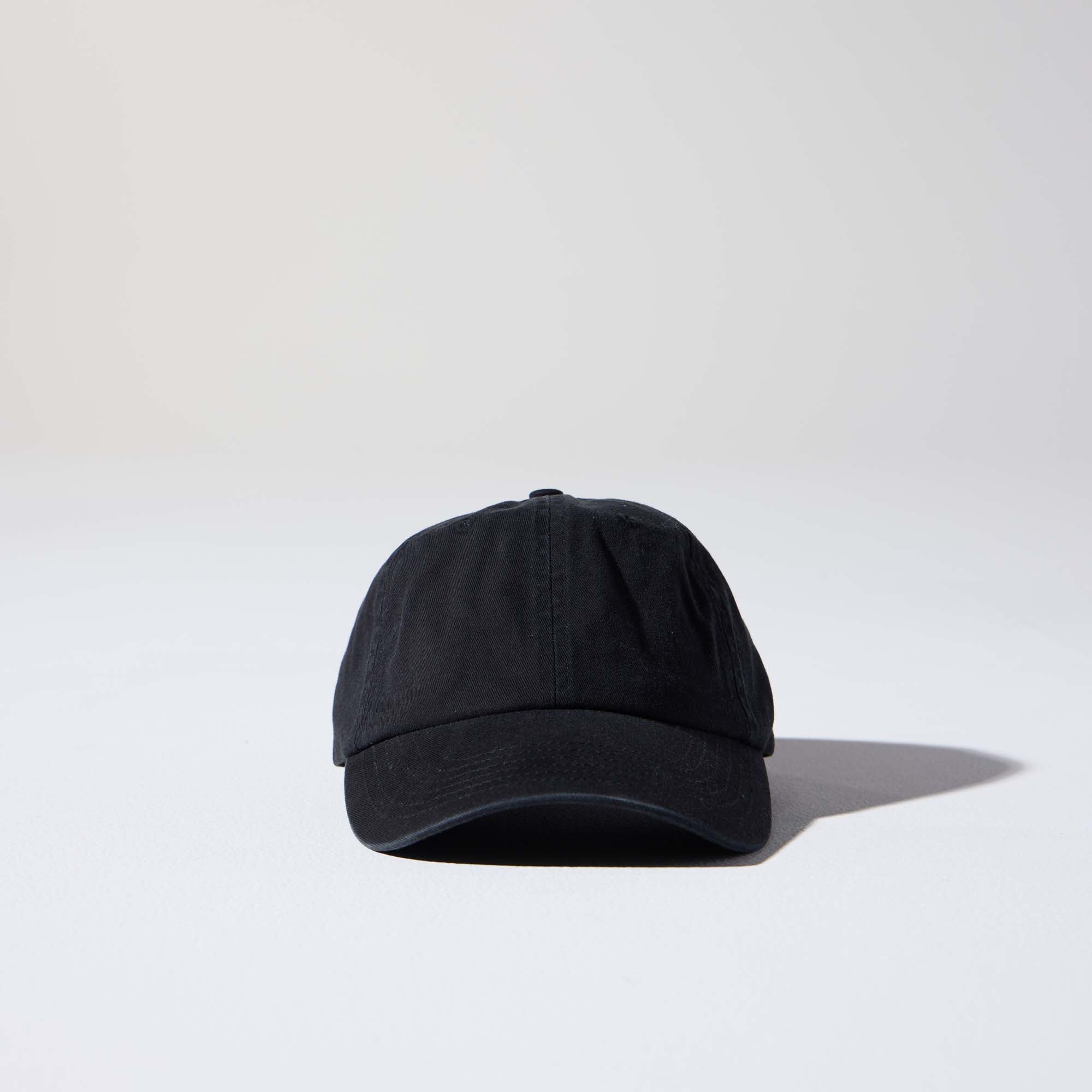 A black-coloured, 6-panel unstructured 'Dad' cap made of recycled cotton twill with an adjustable material buckle. Best Blank Hats by House of Peaks.
