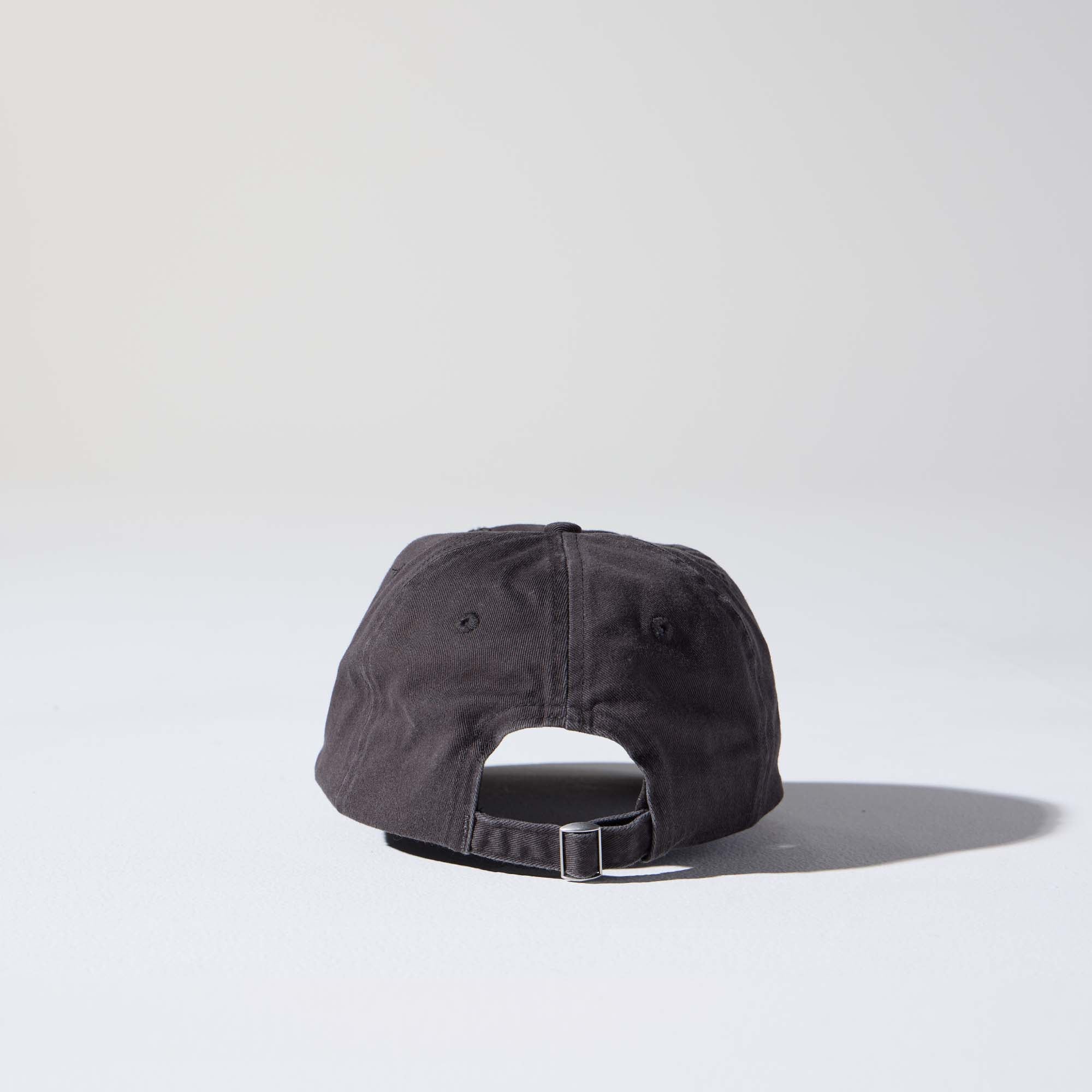 A dark charcoal-coloured, 6-panel unstructured 'Dad' cap made of recycled cotton twill with an adjustable material buckle. Best Blank Hats by House of Peaks.