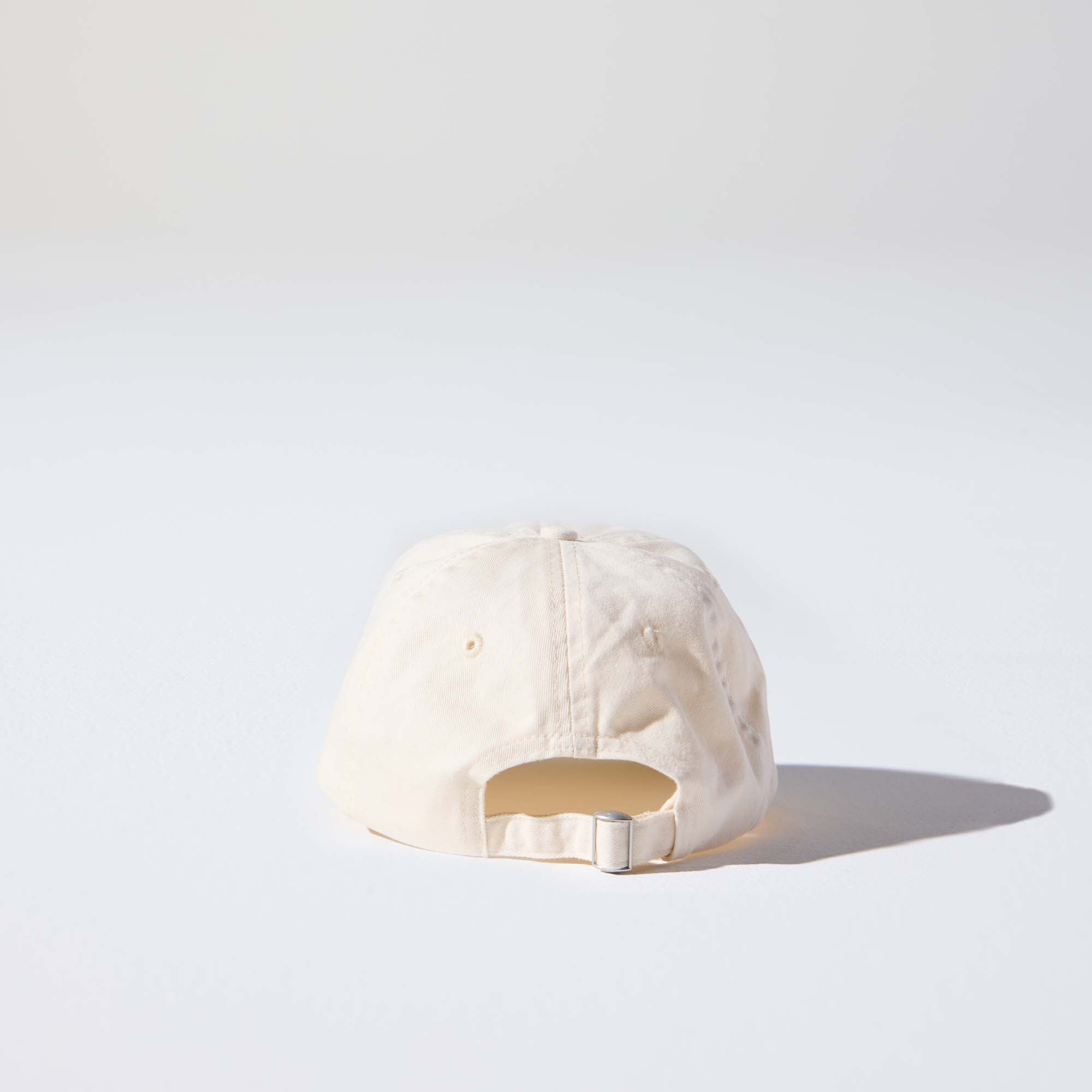 A creamy natural-coloured, 6-panel unstructured 'Dad' cap made of recycled cotton twill with an adjustable material buckle. Best Blank Hats by House of Peaks.