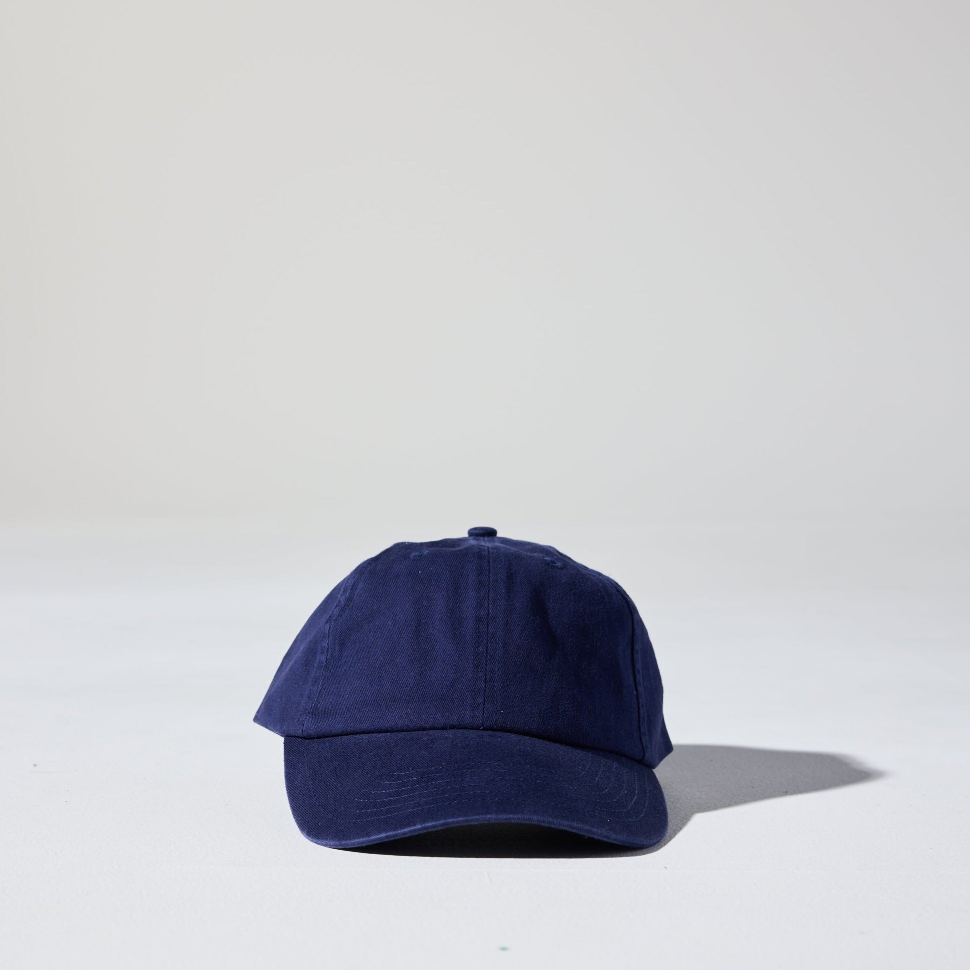 A navy blue, 6-panel unstructured 'Dad' baseball cap made of recycled cotton twill with snap back by House of Peaks.