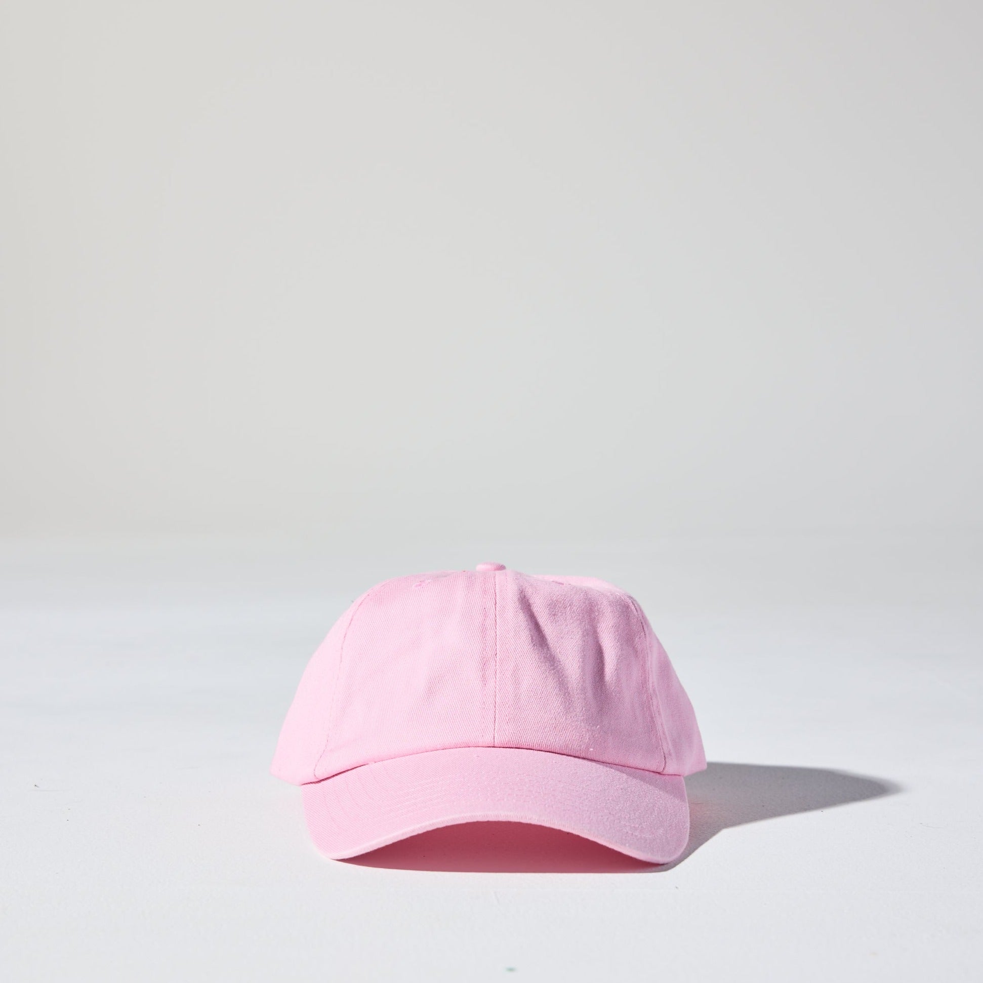 A pastel pink coloured, 6-panel unstructured 'Dad' baseball cap made of recycled cotton twill with snap back by House of Peaks.
