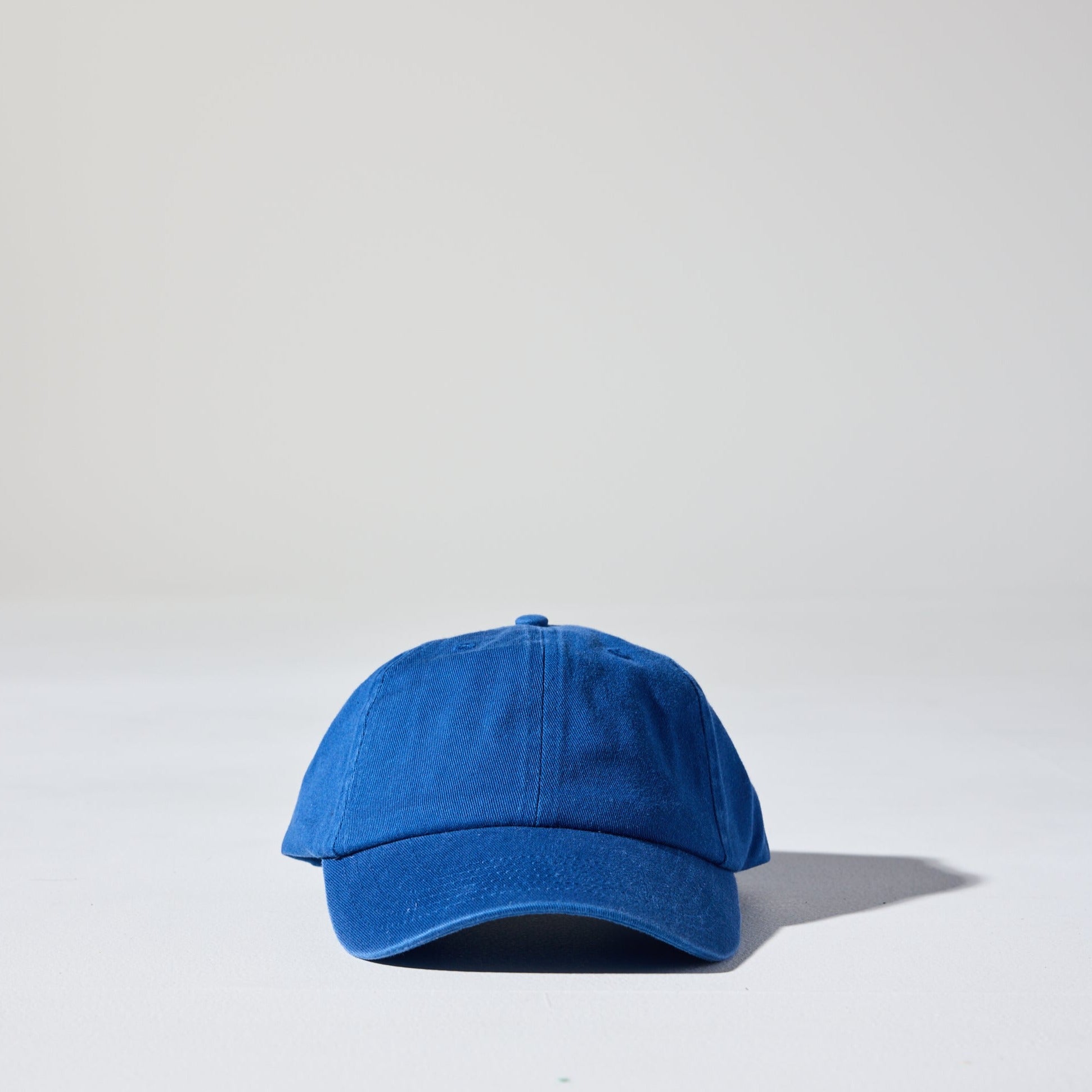 A royal blue coloured, 6-panel unstructured 'Dad' baseball cap made of recycled cotton twill with snap back by House of Peaks.