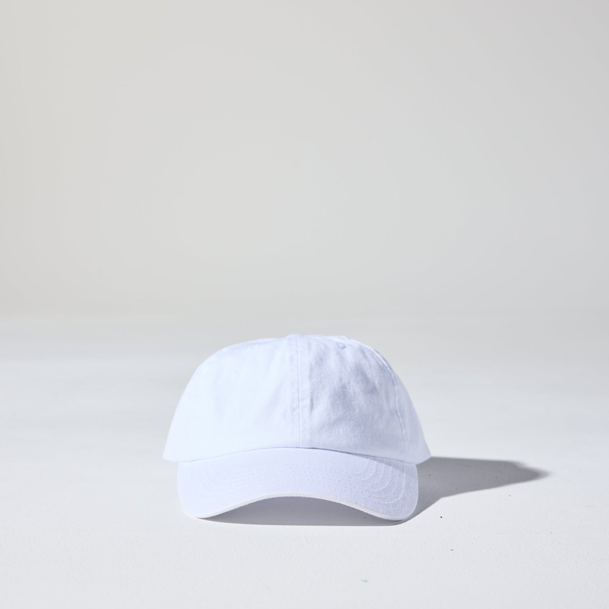 A crisp white, 6-panel unstructured 'Dad' baseball cap made of recycled cotton twill with snap back by House of Peaks.