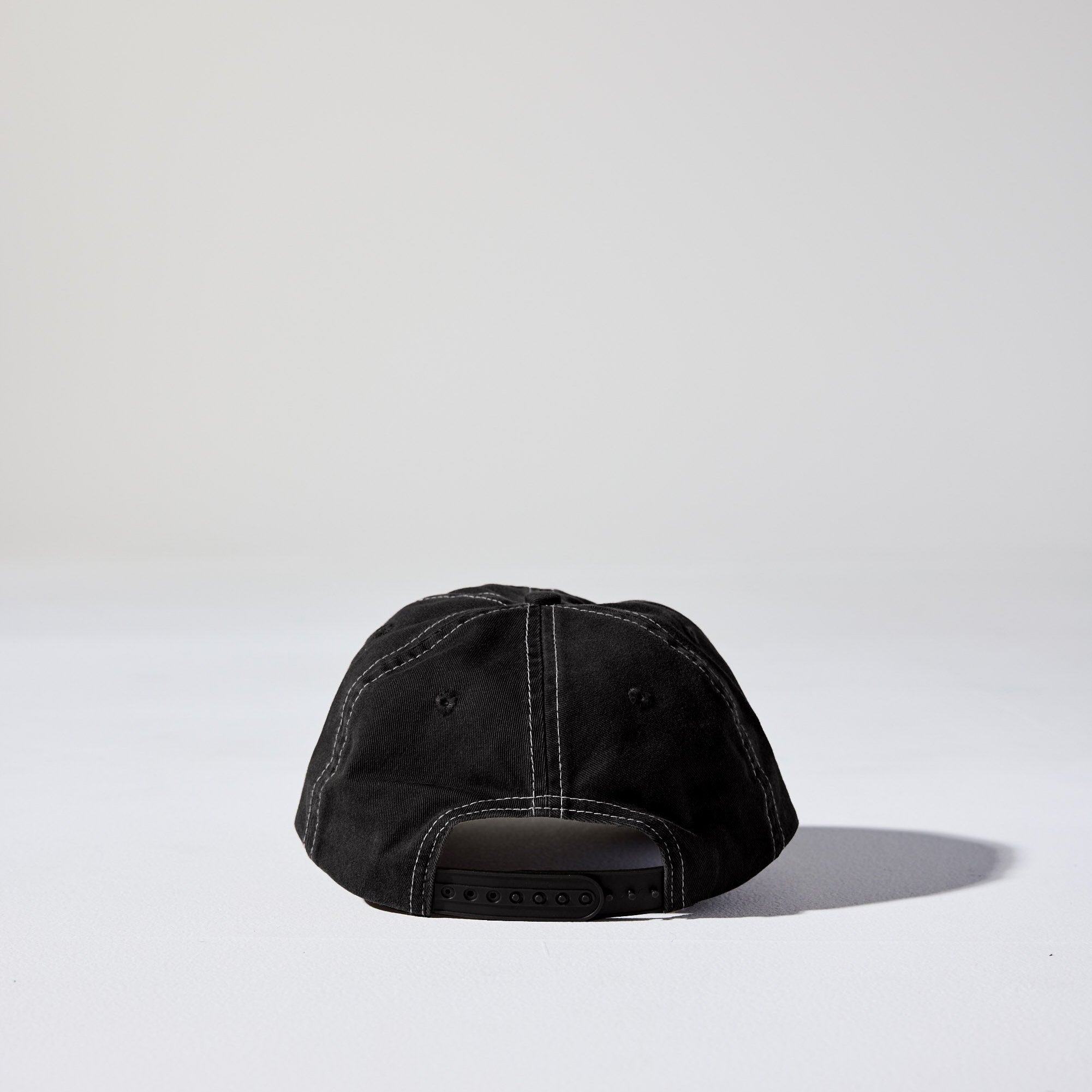 A black 6 panel 'Dad' cap with white contrast stitching and an adjustable plastic snapback adjustment. Best Blank Hats by House of Peaks.