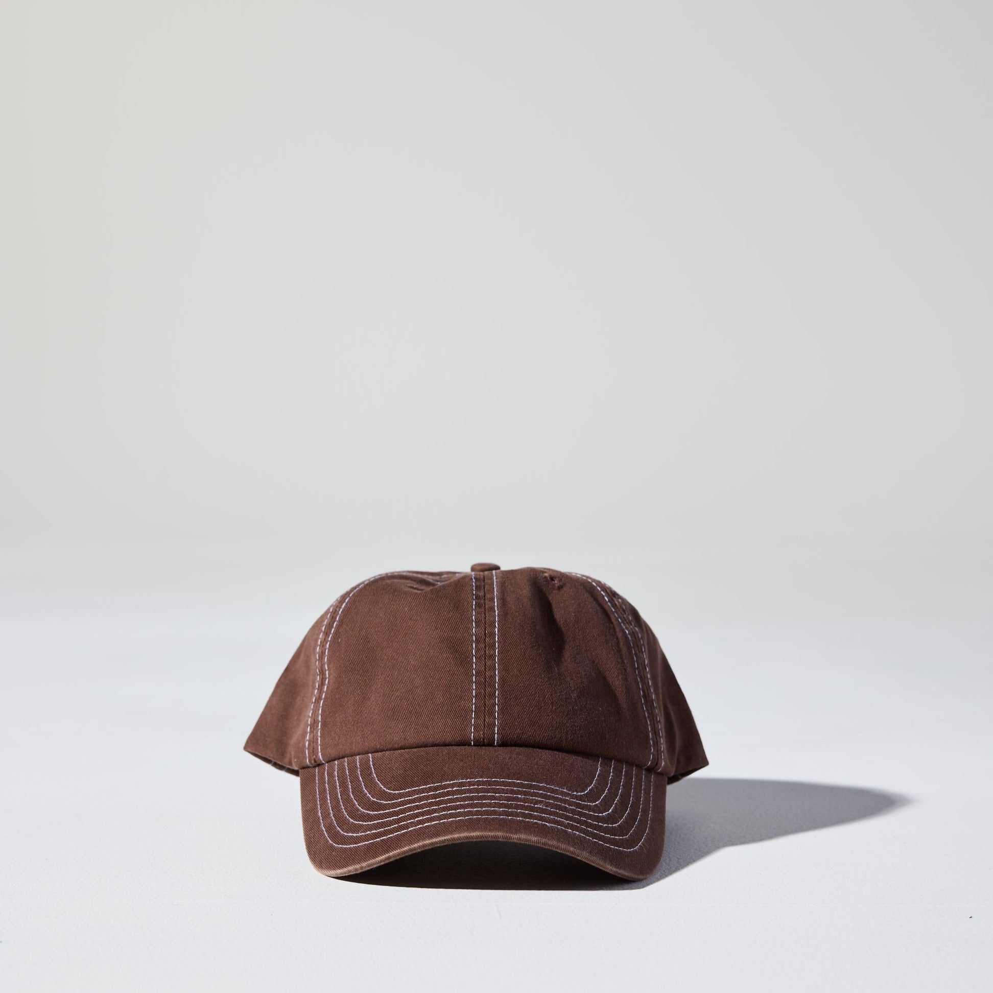 A vintage cacao brown 6 panel 'Dad' cap with white contrast stitching and an adjustable plastic snapback adjustment. Best Blank Hats by House of Peaks.