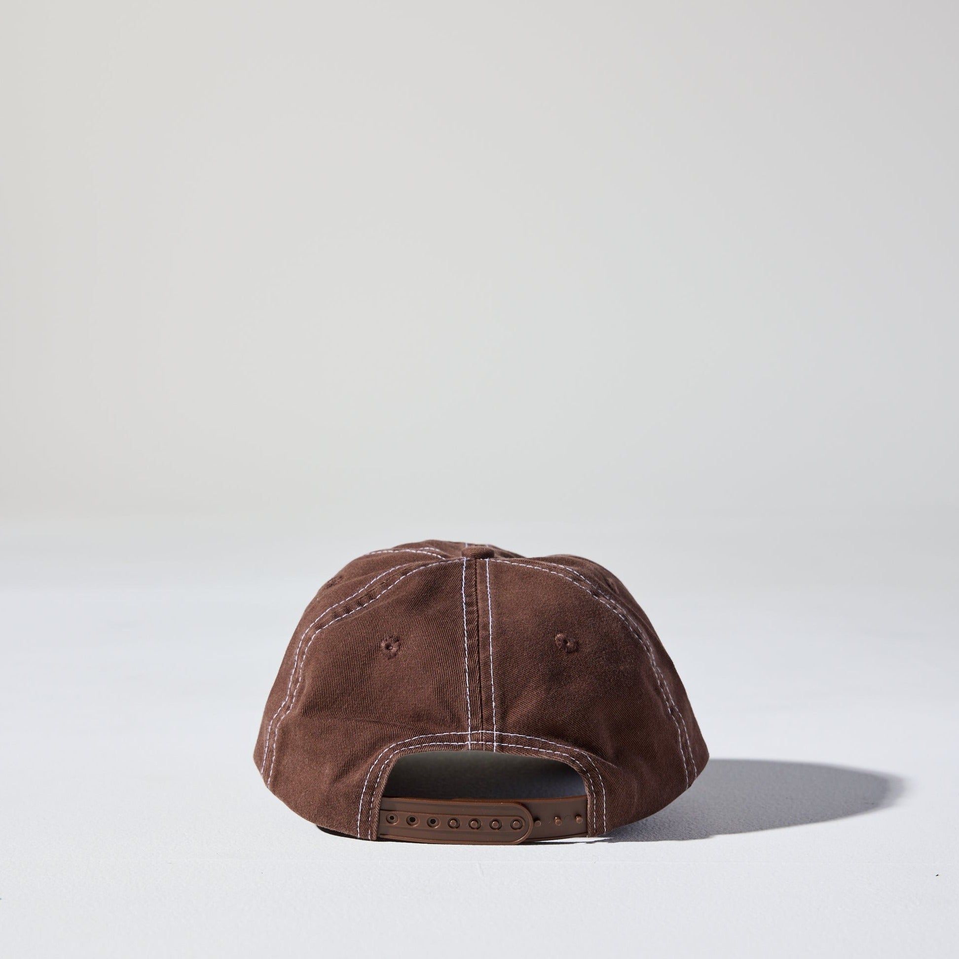 A vintage cacao brown 6 panel 'Dad' cap with white contrast stitching and an adjustable plastic snapback adjustment. Best Blank Hats by House of Peaks.