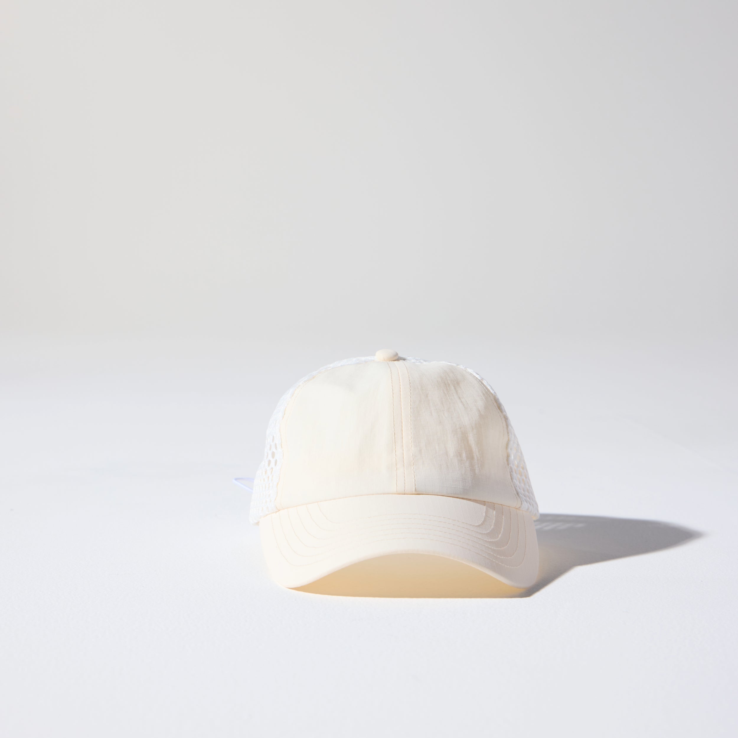 Friday Mesh Cap in Cream by House of Peaks – recycled nylon running hat with breathable mesh and bungee cord.