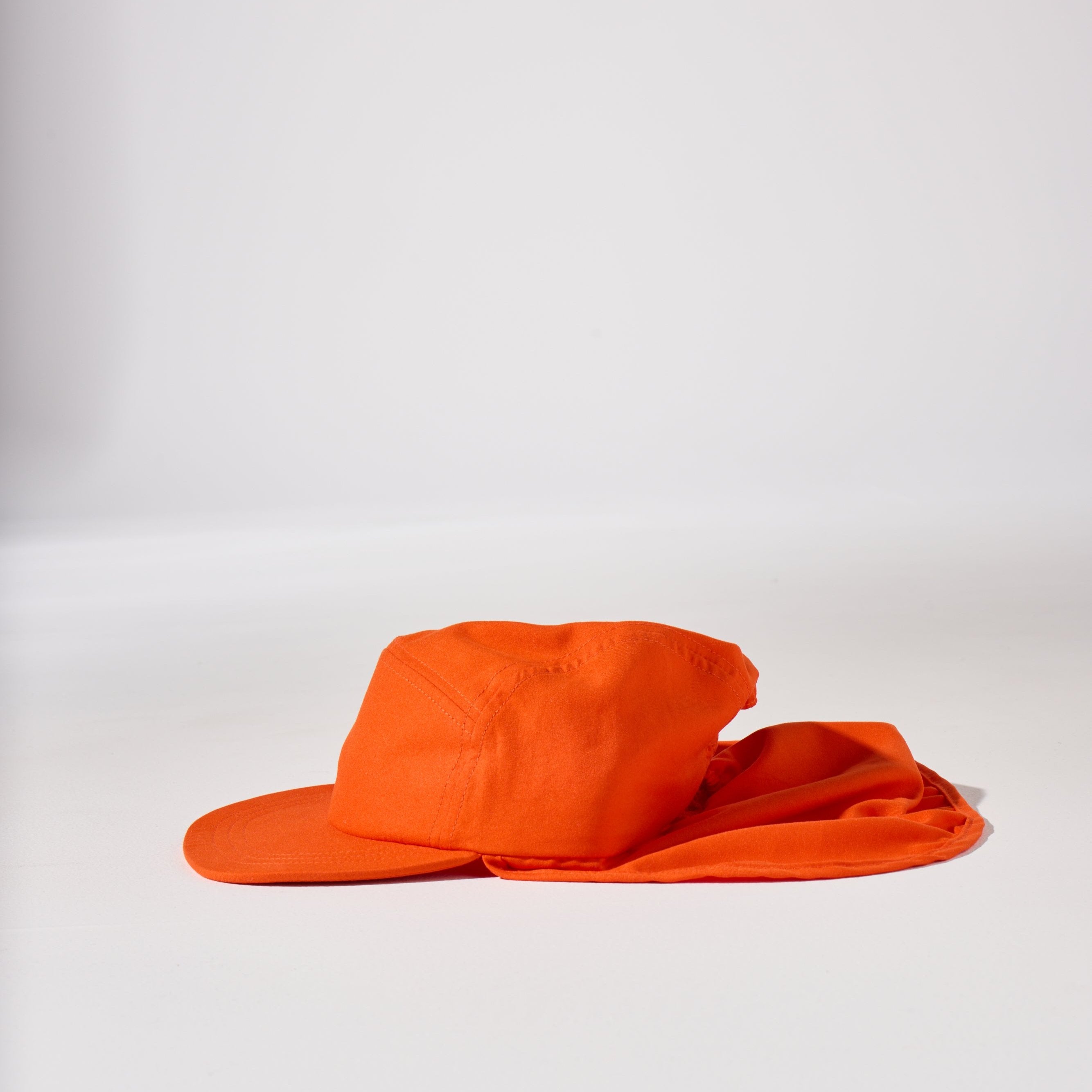 An orange holiday legionnaire sun protection cap by House of Peaks with neck flap and an adjustable bungee cord.