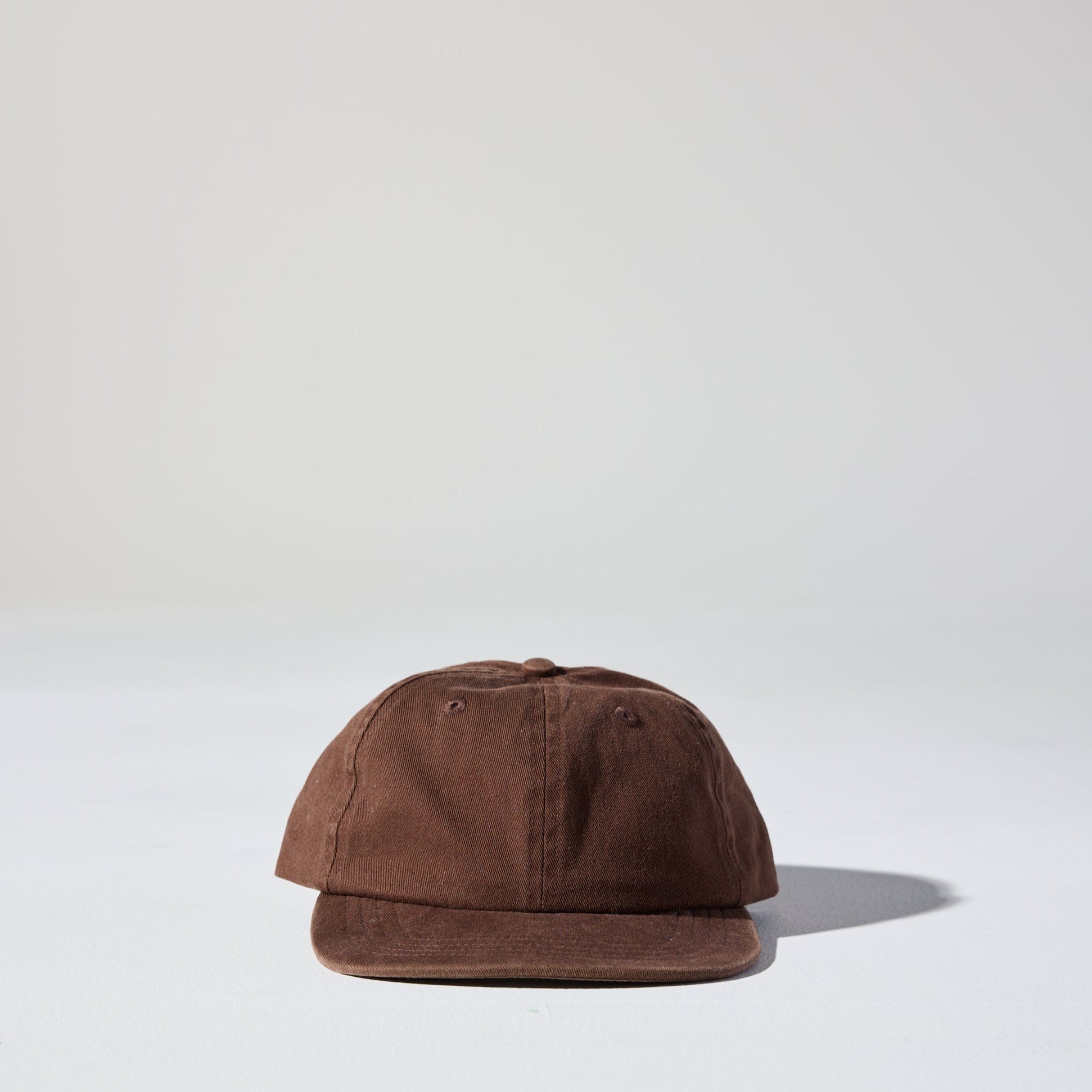 A retro style faded cocoa brown Monday Buckle Cap by House of Peaks with an adjustable strap, placed against a white background.