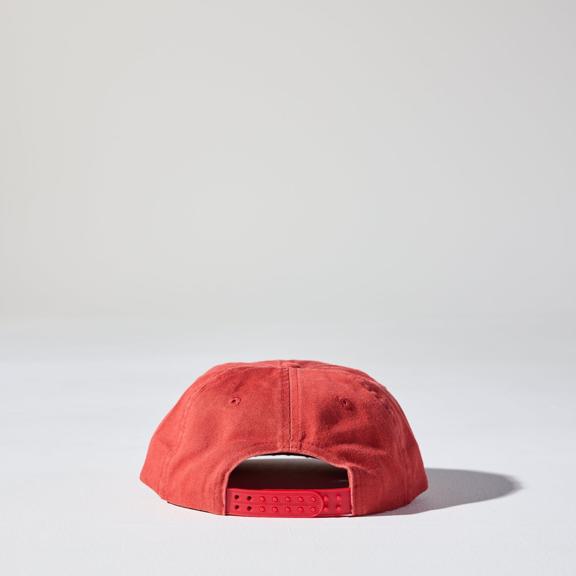 A red 6 panel snapback cap made of recycled cotton twill, displayed against a neutral background.