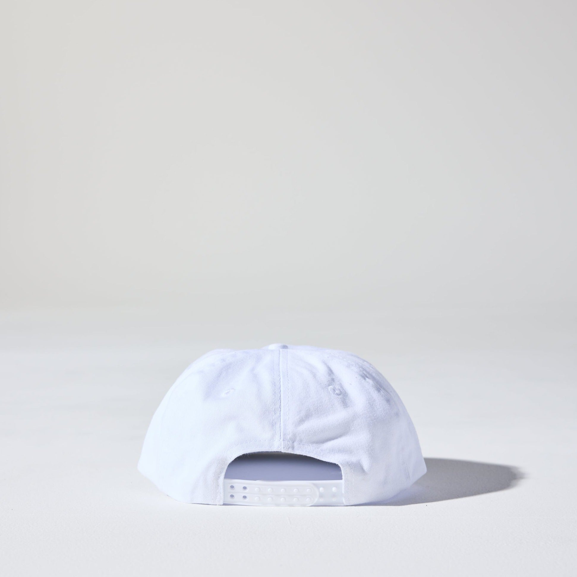 A white retro style 6 panel snapback cap made of recycled cotton twill. This Monday Snap Cap features a soft unstructured peak.