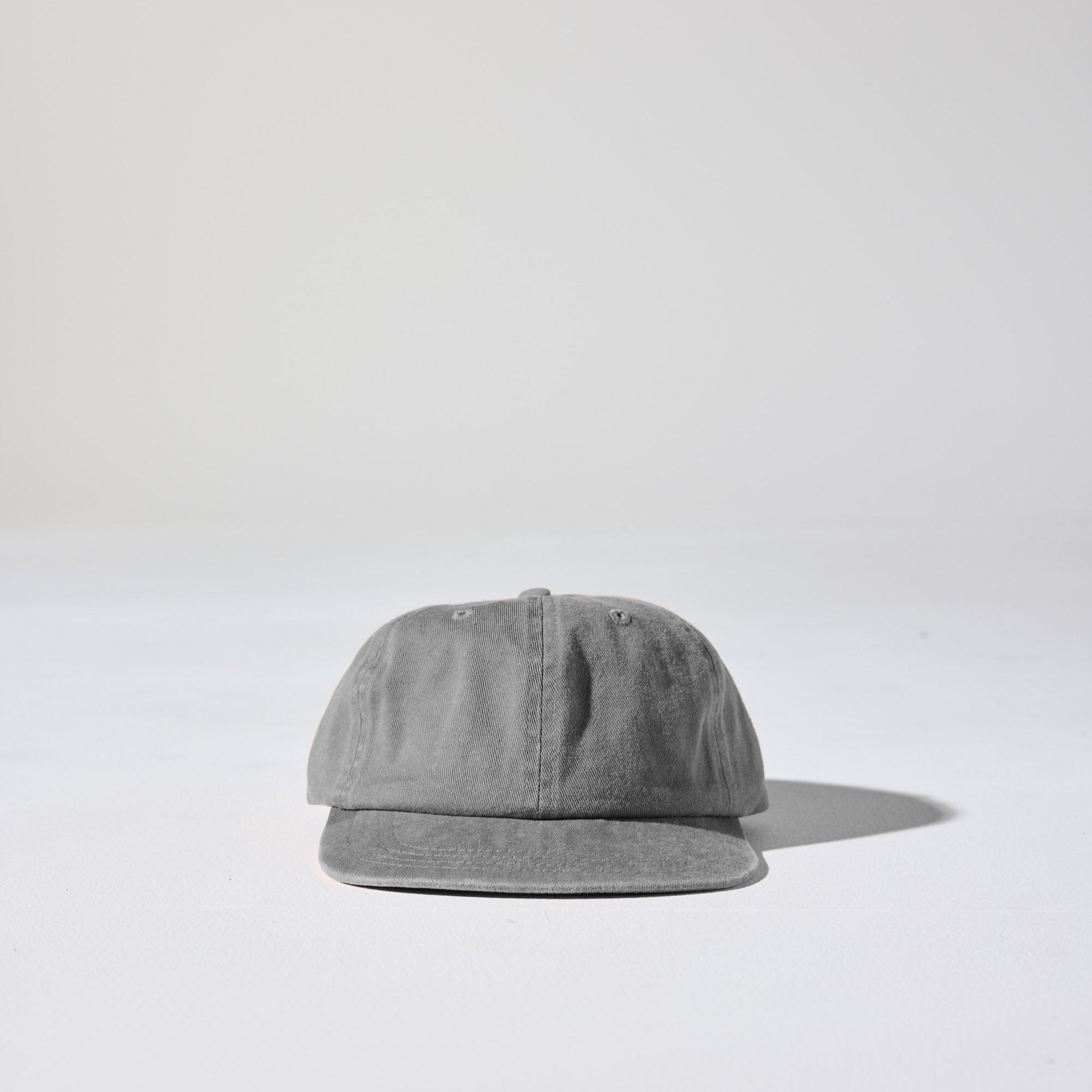 A faded charcoal grey, retro style Monday Buckle Cap by House of Peaks with an adjustable strap, placed against a white background.