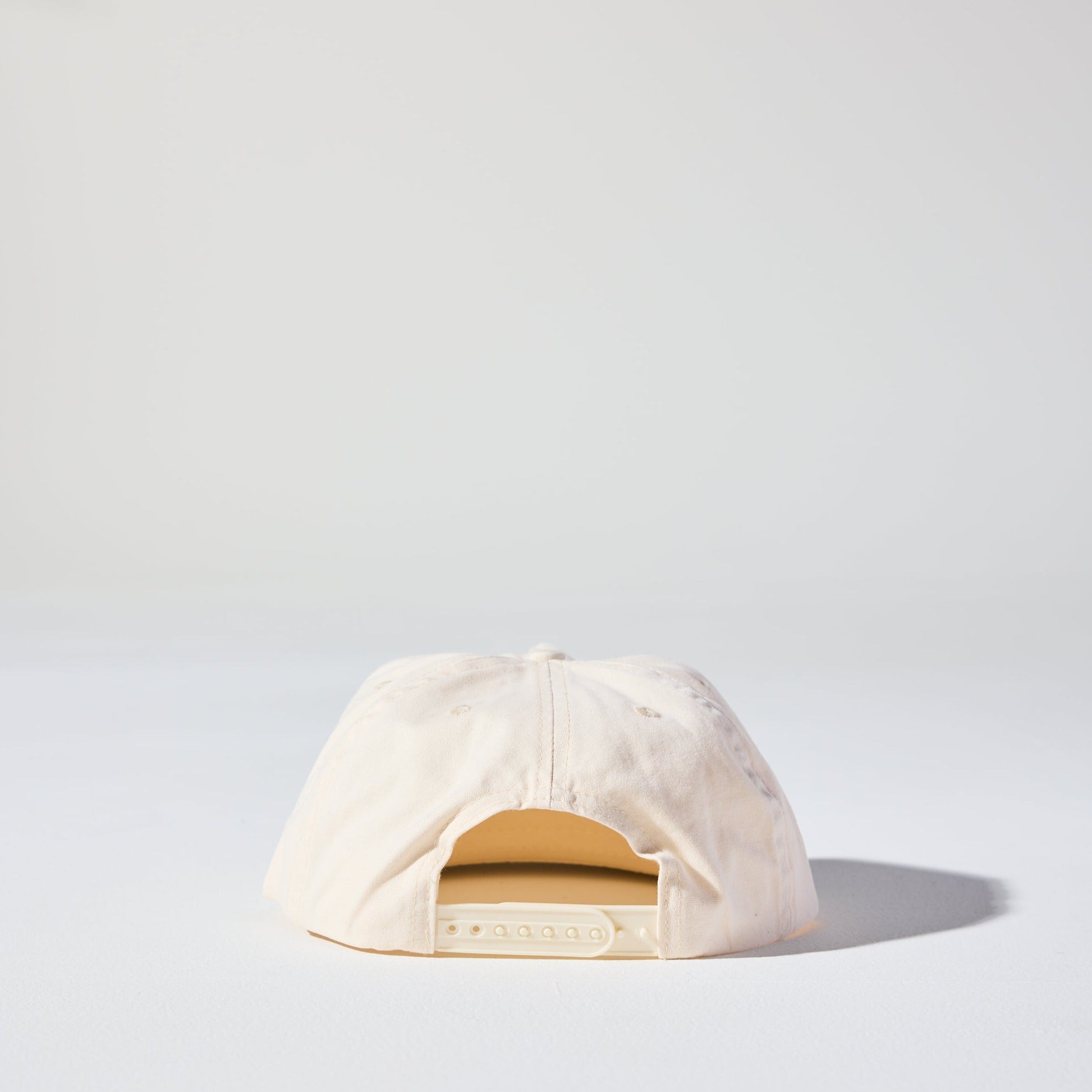 The Tomorrow Cap by House of Peaks is an ivory beige 5 panel structured cap with a flat peak and an adjustable snap closure. Perfect for larger heads.