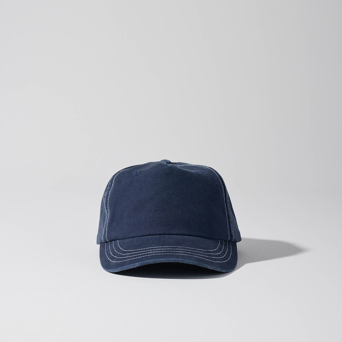 Short Peak Full Curve 5 panel cap. Structured Curved Peak. Vintage Navy with contrast white stitching. Baseball cap. Australian hats. 