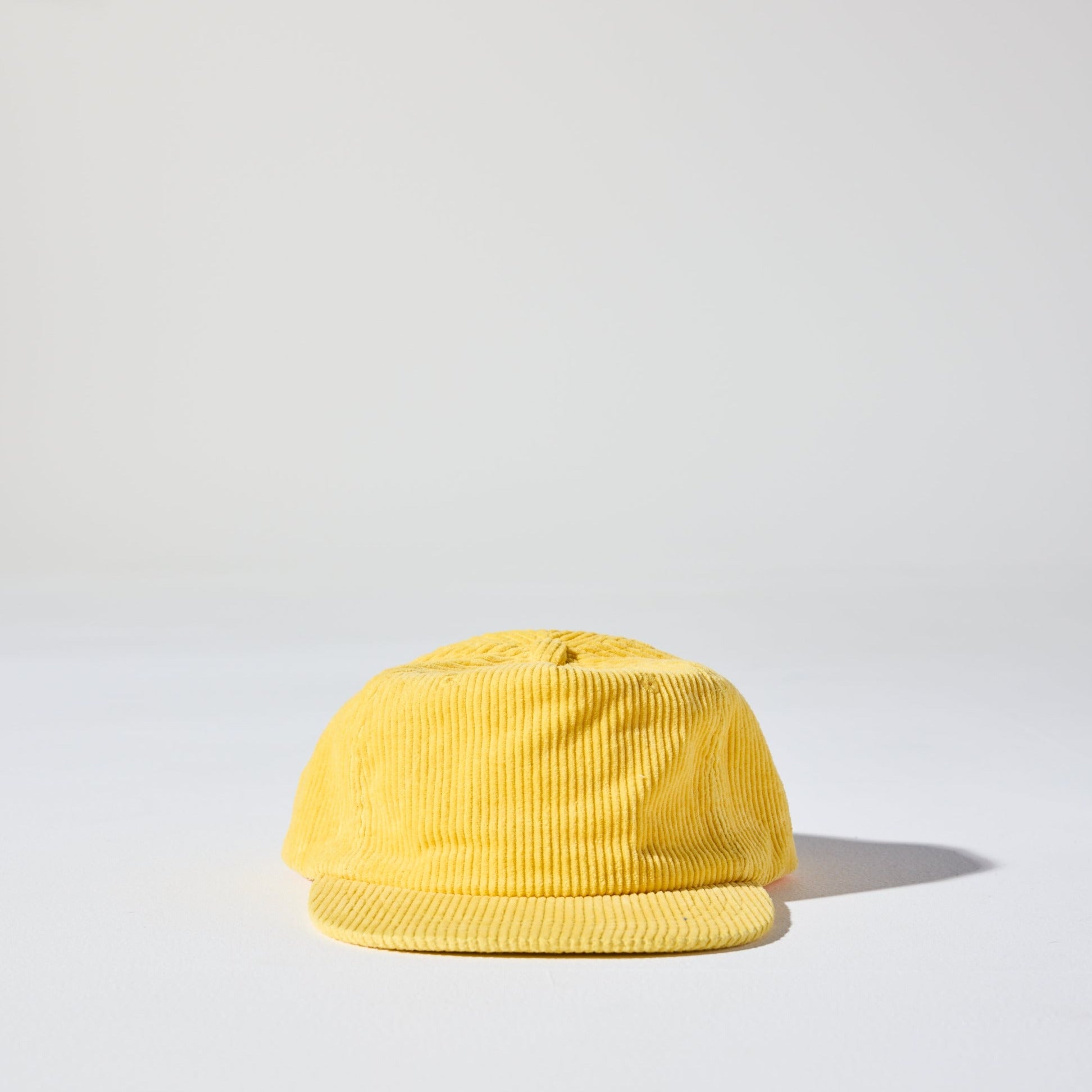 A retro yellow five-panel corduroy cap with a flat brim and adjustable plastic fastener by House of Peaks.