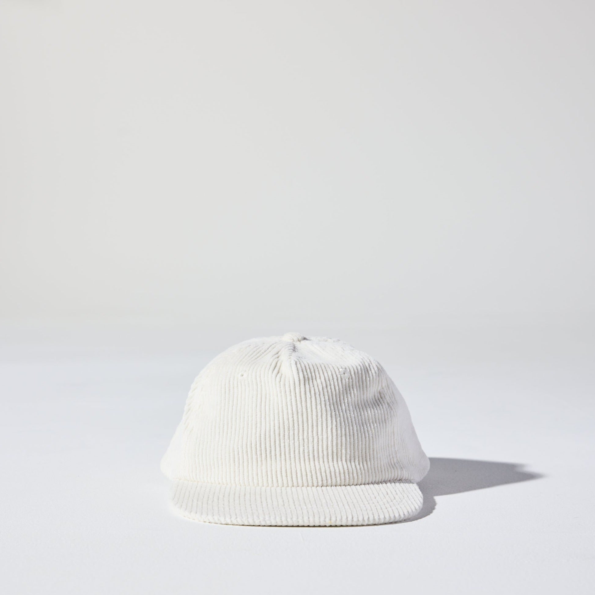 A retro white five-panel corduroy cap with a flat brim and adjustable plastic snapback by House of Peaks.