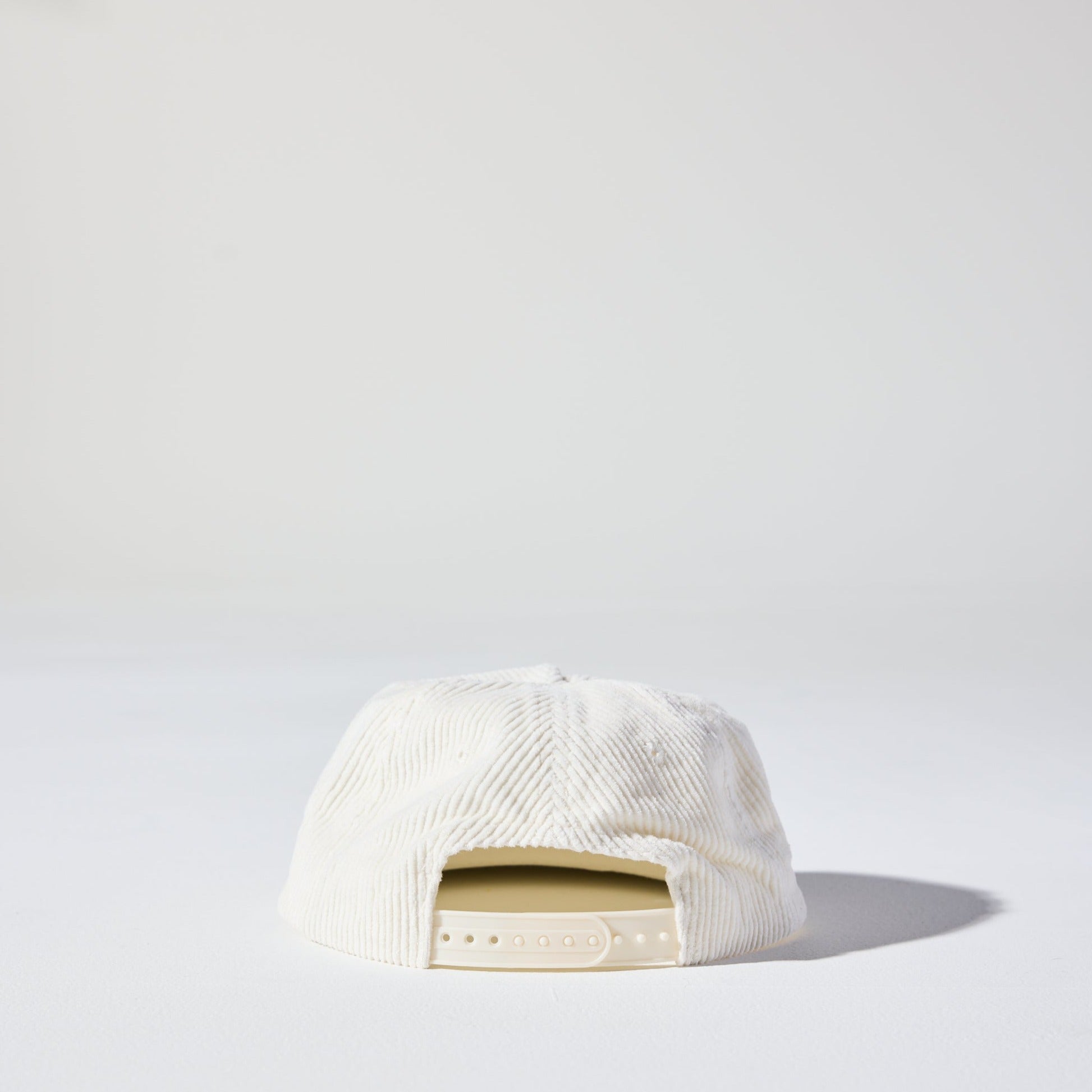 A retro white five-panel corduroy cap with a flat brim and adjustable plastic fastener by House of Peaks.