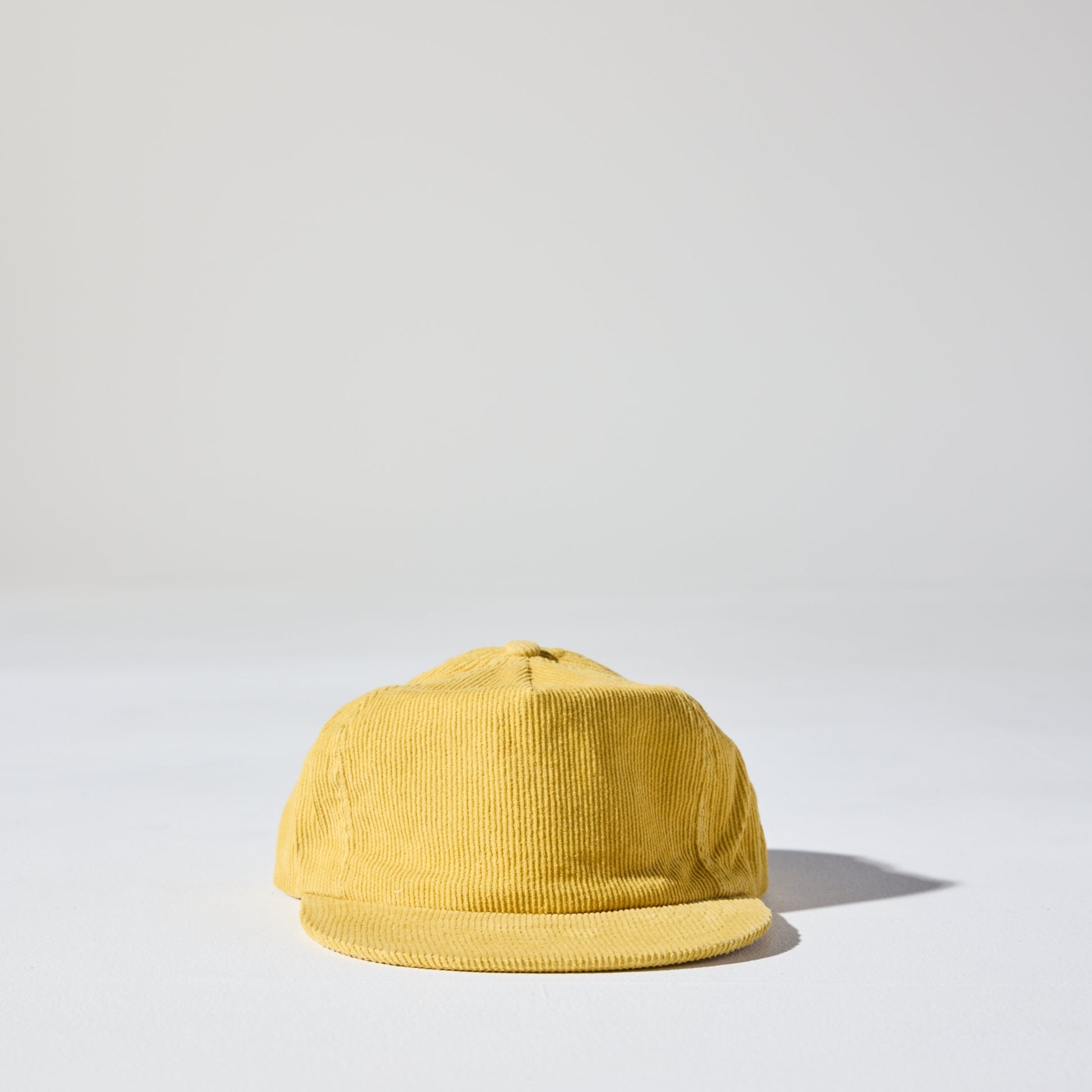 A mustard yellow corduroy unstructured 5 panel cap with an adjustable fastener by House of Peaks, Best blank hats in Australia.