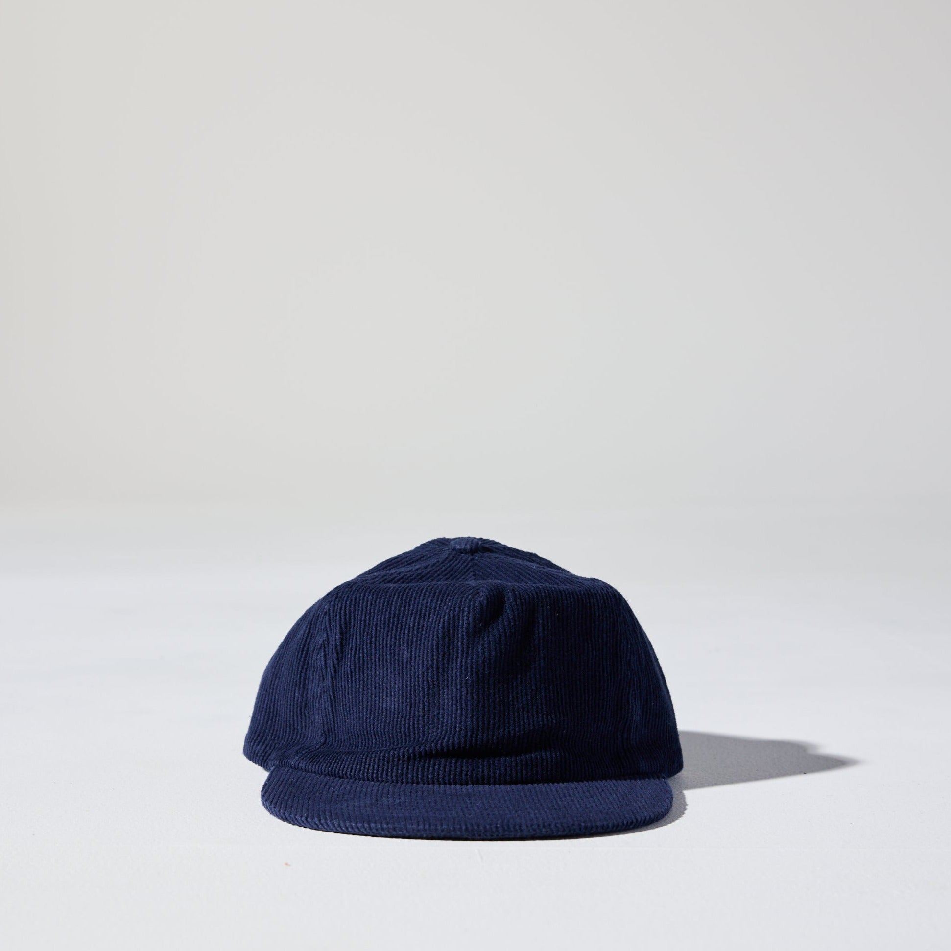 A navy blue corduroy unstructured 5 panel cap with an adjustable fastener by House of Peaks, Best blank hats in Australia.